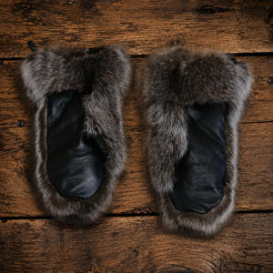 Luxury Canadian raccoon fur mittens in natural grey and black tones with a soft, full fur texture, displayed on a light neutral background. Handcrafted winter mittens offering exceptional warmth and timeless elegance.