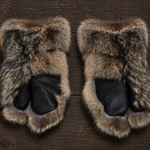 Canadian raccoon fur mittens in natural grey and black tones with a soft, full fur texture, displayed on a light neutral background. Handcrafted winter mittens offering exceptional warmth and timeless elegance.