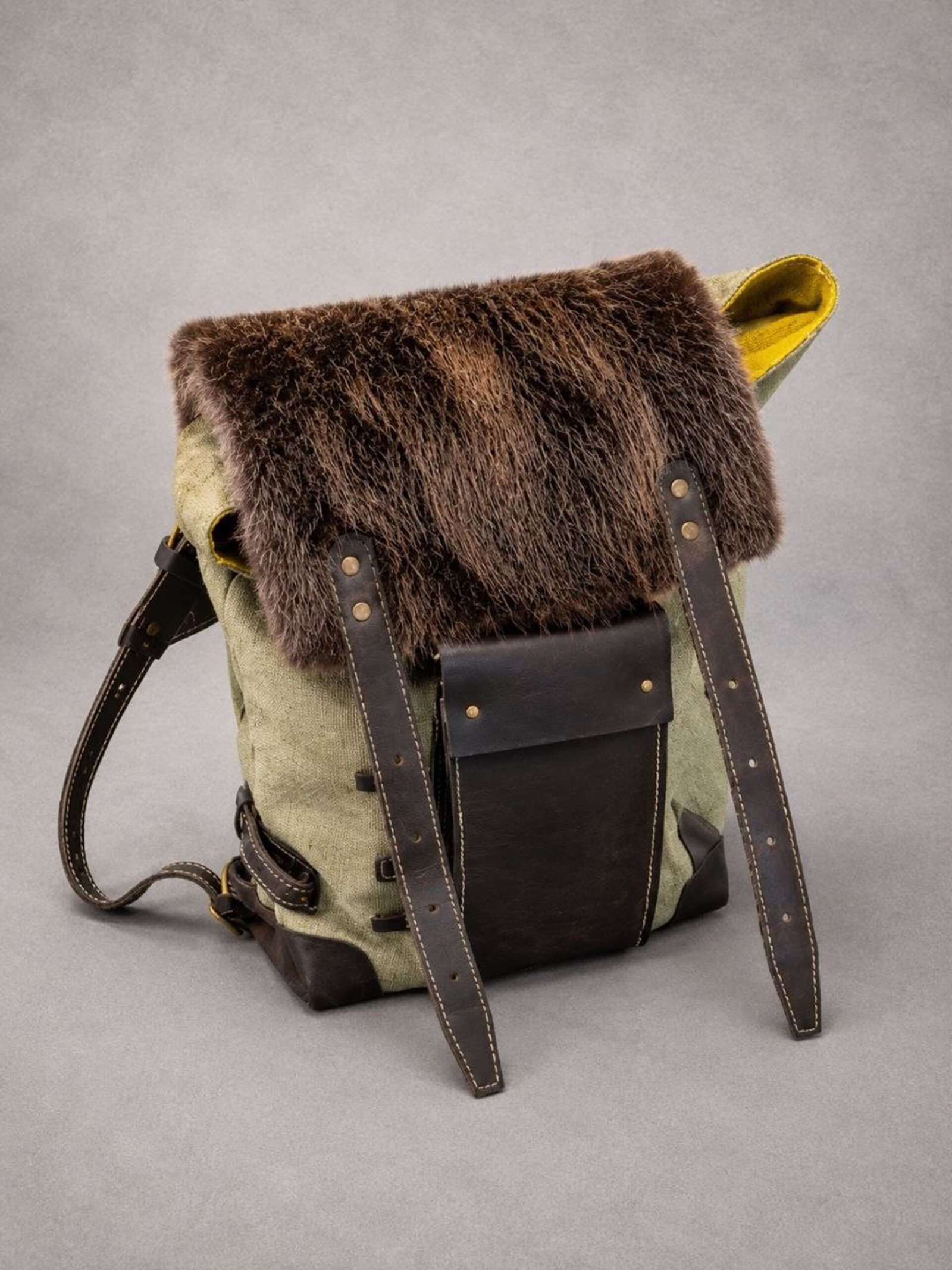 Handcrafted beaver fur backpack with waxed canvas body and full-grain leather details.