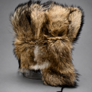 Handcrafted coyote fur ushanka hat made from premium natural coyote fur with ear flaps, photographed in a professional gray studio setting.
